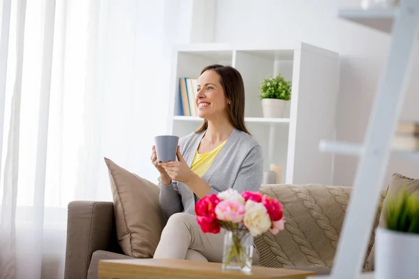 Šťastná žena pít čaj nebo kávu doma — Stock fotografie