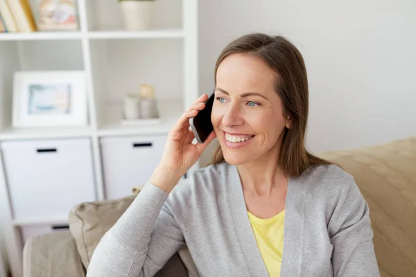 Happy woman calling on smartphone at home — Stock Photo, Image