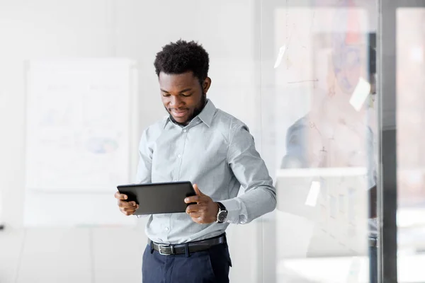 Sonriente hombre de negocios con tablet pc en la oficina — Foto de Stock