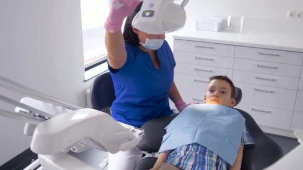 Dentista femenina con niño paciente en la clínica dental — Vídeo de stock