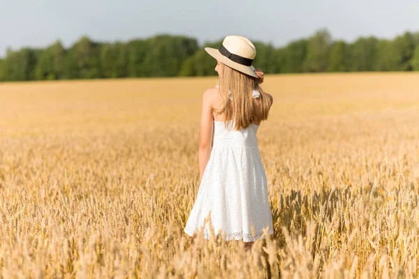 Portret van meisje in stro hoed op het veld in de zomer — Stockfoto