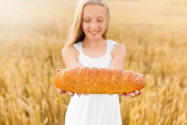 Ragazza con pagnotta di pane bianco sul campo di cereali — Foto Stock