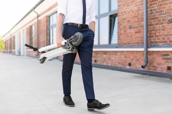 Affärsman med hopfällbar skoter på taket — Stockfoto