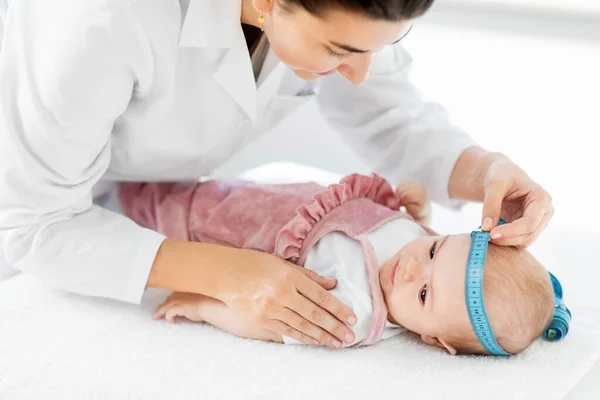 Лікар-педіатр, який вимірює голову немовлят у клініці — стокове фото
