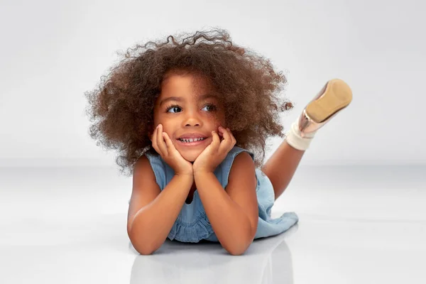 Feliz pequeña afroamericana chica acostada en el suelo — Foto de Stock