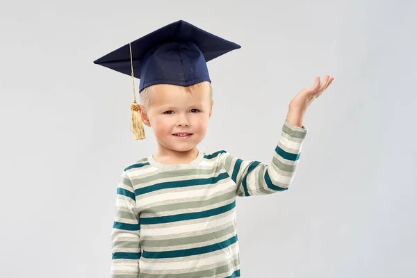 Little boy in mortar board with empty hand — Stock Photo, Image