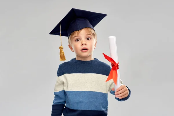 Kleine jongen in mortierbord met diploma — Stockfoto