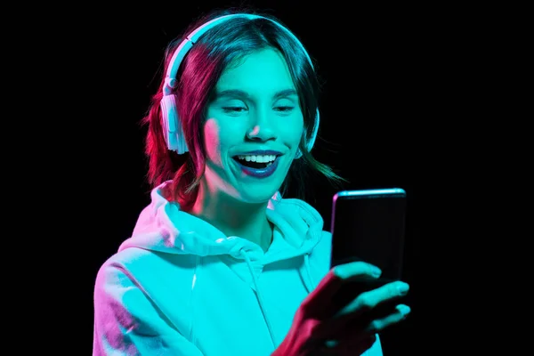 Femme dans casque avec smartphone dans les néons — Photo