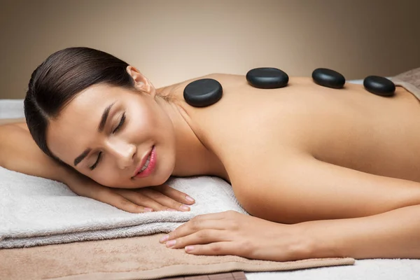 Mujer teniendo masaje de piedra caliente en el spa —  Fotos de Stock