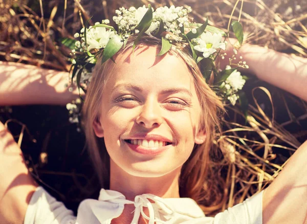 Mulher feliz na grinalda de flores deitado na palha — Fotografia de Stock