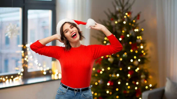 Gelukkig jong vrouw in santa hoed op kerst — Stockfoto