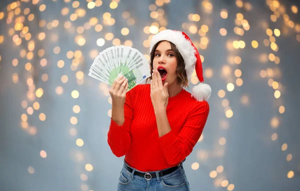 Donna in cappello da Babbo Natale con soldi a Natale — Foto Stock