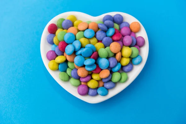 Caramelos en forma de corazón placa sobre fondo azul —  Fotos de Stock