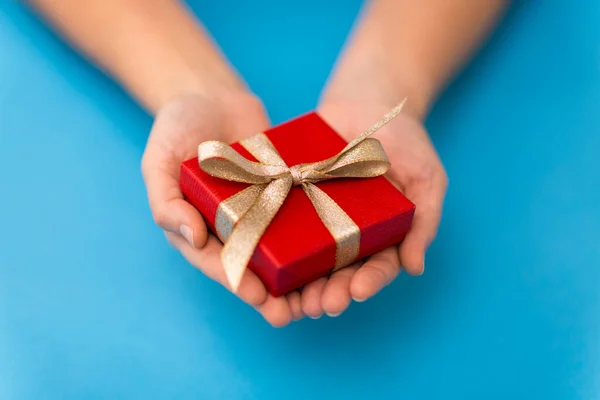 Mãos segurando vermelho pequena caixa de presente de Natal — Fotografia de Stock