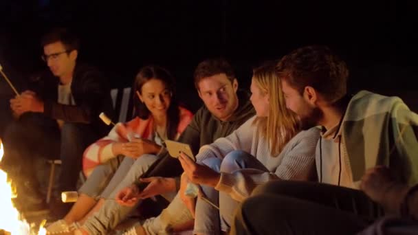 Freunde mit Marshmallow und Smartphone am Feuer — Stockvideo