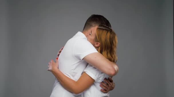 Feliz casal abraçando sobre fundo cinza — Vídeo de Stock