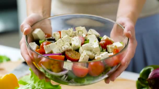 Woman holding bowl of vegetable salad with feta — Stock Video