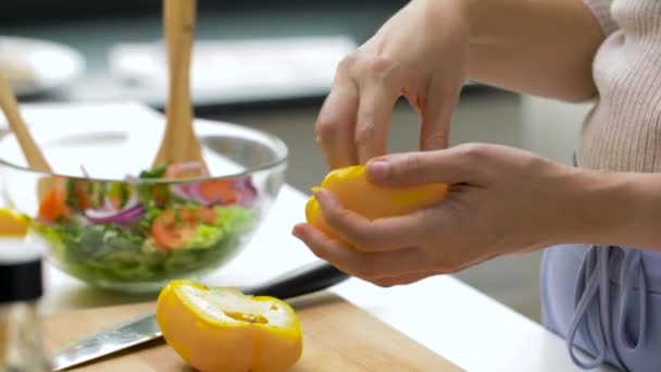 Woman cutting pepper in half and removing seeds — ストック動画