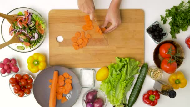 Woman chopping carrot with kitchen knife at home — Stock Video