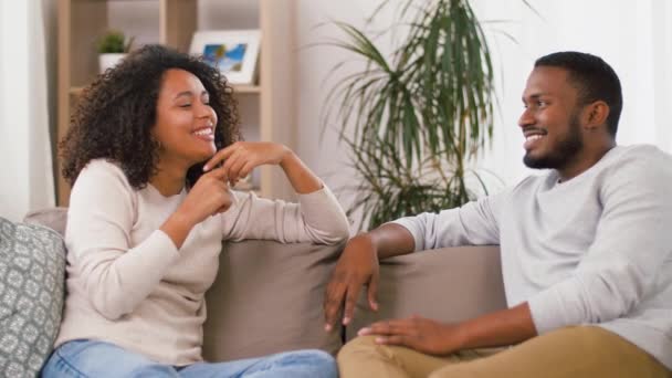 Lyckliga paret sitter på soffan och pratar hemma — Stockvideo