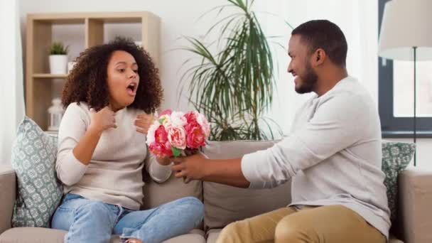 Glückliches Paar mit Blumenstrauß küsst sich zu Hause — Stockvideo