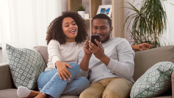 Afrikanskt amerikanskt par med smartphone hemma — Stockvideo