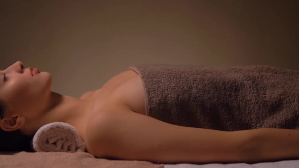Młoda kobieta, leżąc w spa lub gabinet masażu — Wideo stockowe