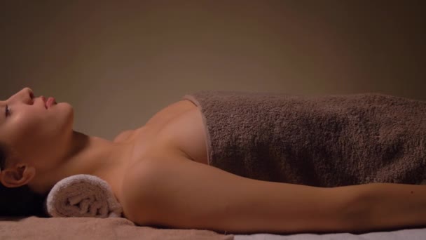 Young woman lying at spa or massage parlor — Stock Video