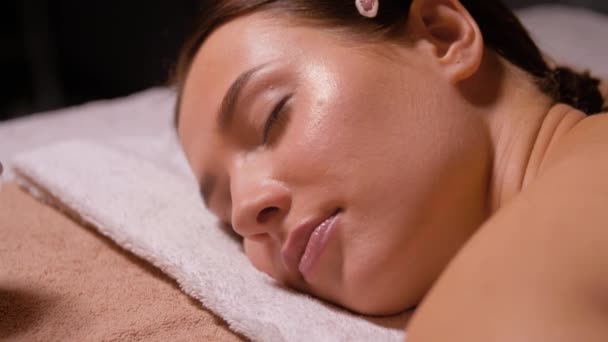 Hermosa mujer teniendo caliente piedra masaje en spa — Vídeos de Stock