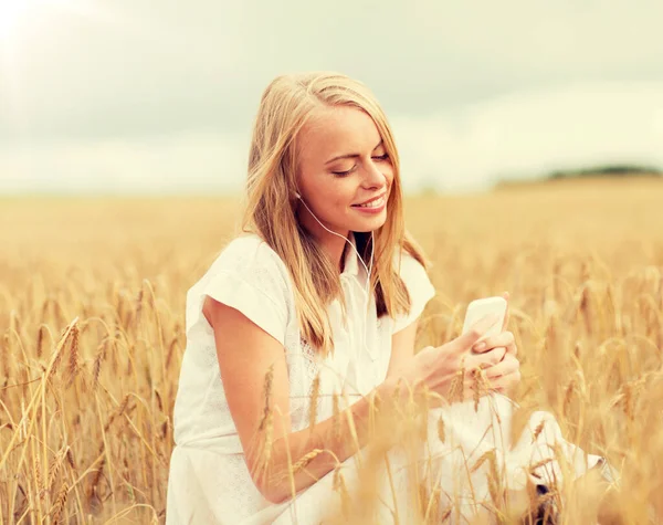 Mujer feliz con smartphone y auriculares — Foto de Stock