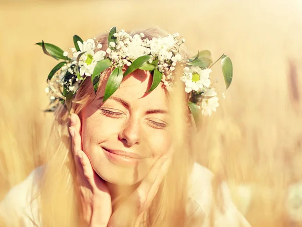 Gelukkig vrouw in krans van bloemen op graan veld — Stockfoto