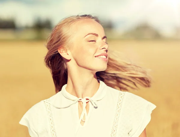 Sorrindo jovem mulher em branco no campo de cereais — Fotografia de Stock