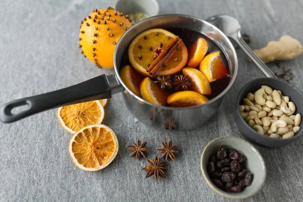 Olla con vino caliente caliente, rodajas de naranja y especias — Foto de Stock