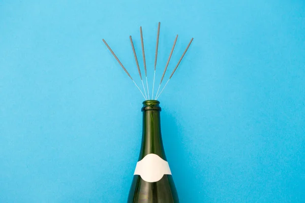 Botella de champán con bengalas en azul — Foto de Stock