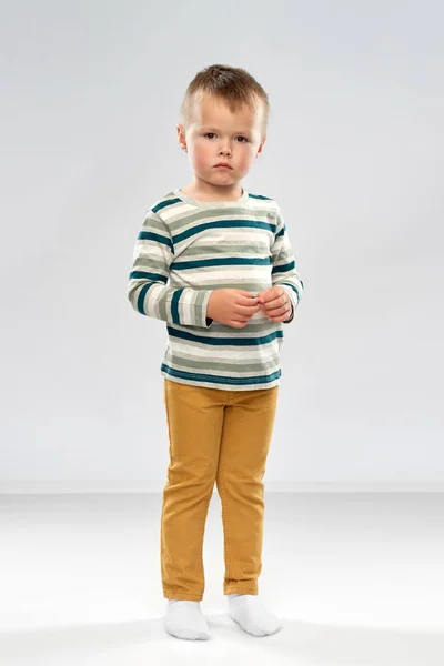 Портрет грустного мальчика в полосатой рубашке — стоковое фото