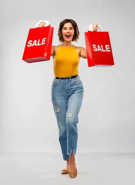 Glad leende ung kvinna med shoppingväskor — Stockfoto