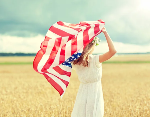 Mulher feliz com bandeira americana no campo de cereais — Fotografia de Stock