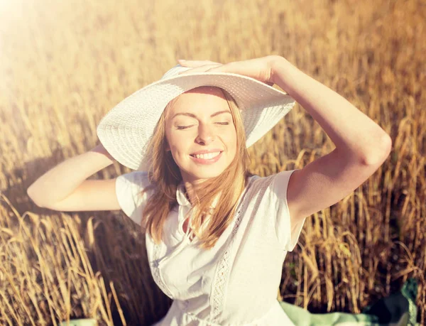 Felice giovane donna in cappello da sole sul campo di cereali — Foto Stock