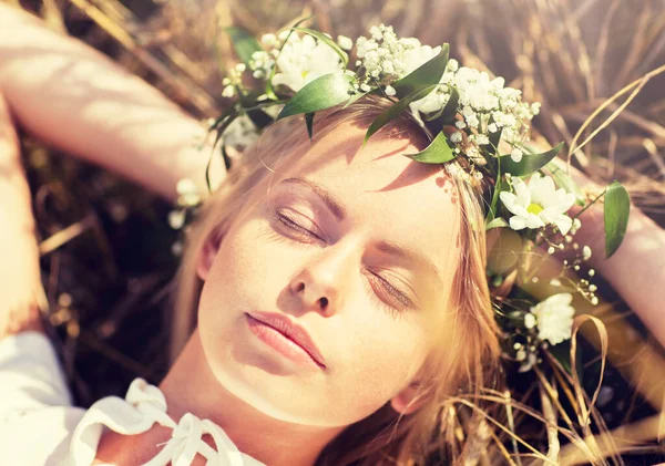 Mujer feliz en corona de flores acostada sobre paja — Foto de Stock