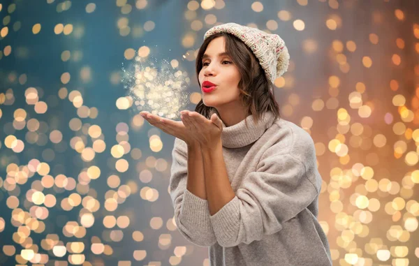 Jonge vrouw in gebreide winter hoed verzenden lucht kus — Stockfoto