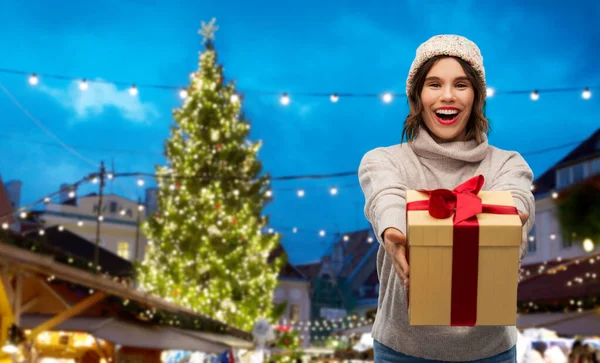 Mujer feliz sosteniendo caja de regalo en el mercado de Navidad —  Fotos de Stock