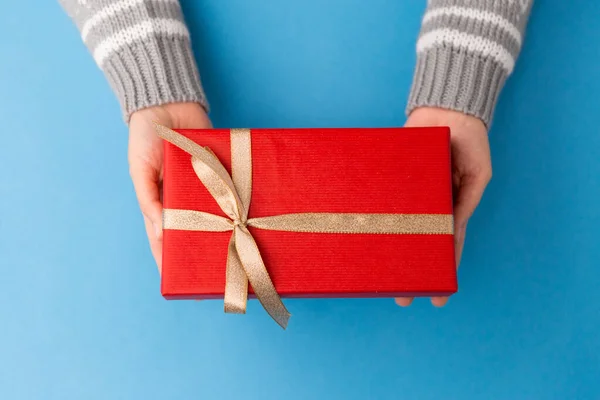 Mãos segurando caixa de presente de Natal vermelho — Fotografia de Stock