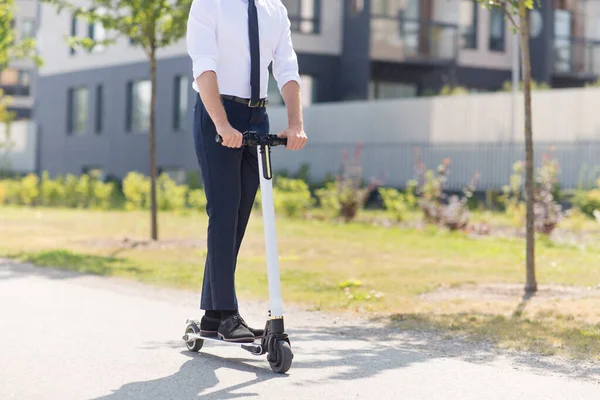 Fiatal üzletember lovaglás elektromos robogó szabadban — Stock Fotó