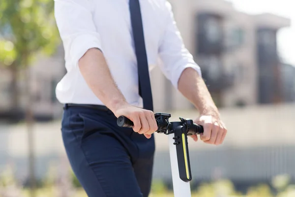 Joven hombre de negocios montar scooter eléctrico al aire libre —  Fotos de Stock