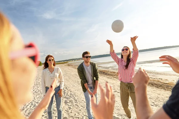 Amigos jugando voleibol en la playa en verano — Foto de Stock