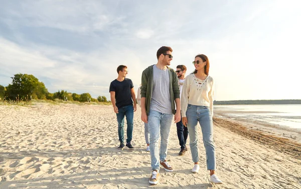 Amigos felices caminando por la playa de verano — Foto de Stock