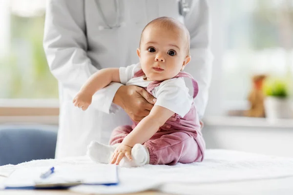 Médico pediatra feminino com bebê na clínica — Fotografia de Stock