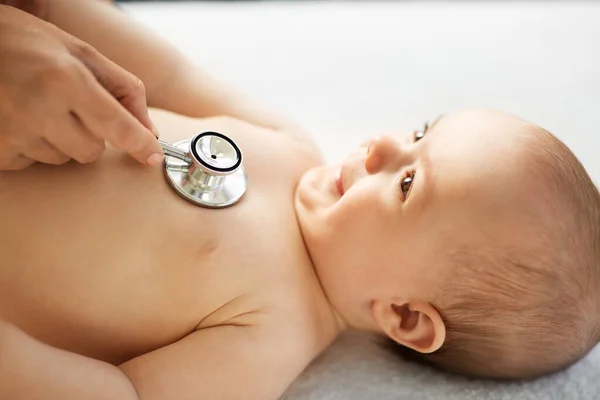 Arzt mit Stethoskop hört Baby-Patientin zu — Stockfoto