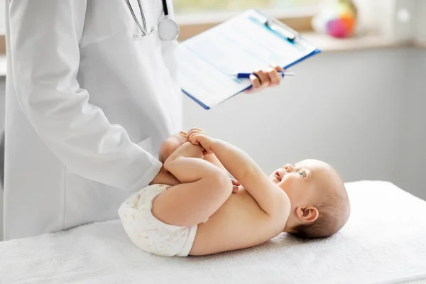 Vrouwelijke kinderarts arts met baby in kliniek — Stockfoto