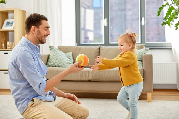 Отец и дочка играют в мяч дома — стоковое фото